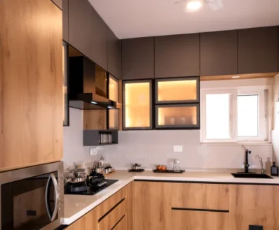 Contemporary L-shaped kitchen interior featuring pastel lower cabinets, open shelving, integrated appliances, and under-cabinet lighting